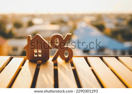 Percentage and house sign symbol icon wooden on wood table. Concepts of home interest, real estate, investing in inflation.
