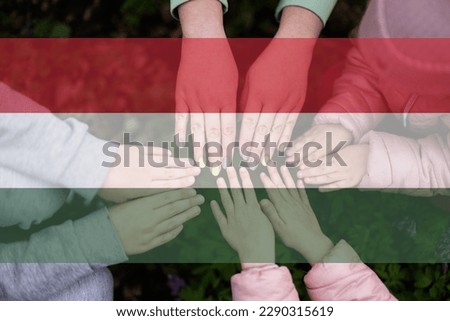 Hands of kids on background of Hungary flag. Hungarian patriotism and unity concept. Royalty-Free Stock Photo #2290315619