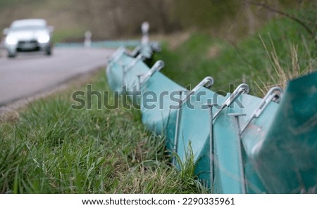 A green plastic toad fence is erected at the roadside. This is to prevent the toads from running over.