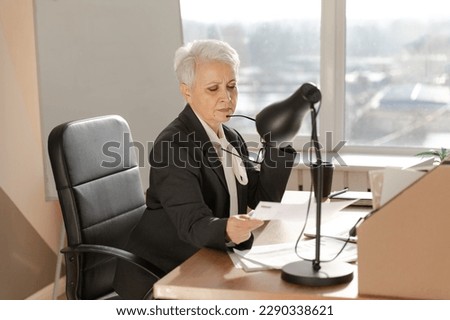 Confident stylish european middle aged senior woman reading financial report documentation statistics. Stylish older mature 60s gray haired lady businesswoman in office. Boss leader teacher Royalty-Free Stock Photo #2290338621