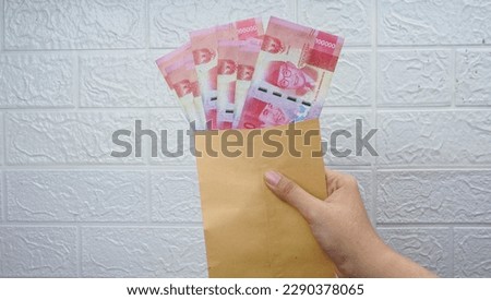 Indonesian money in craft paper envelope isolated white wall background
