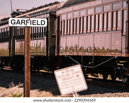 A historical railroad signage post of Garfield and a vintage passing train, California.
