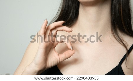 young woman showing a hole with her fingers - showing a gesture for okay