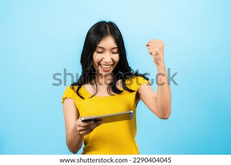 Portrait, beautiful woman with long hair asian, play competitive games with friends on laptop raised her hands in joy that team had won game, Isolated indoor studio on blue background.