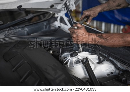 Auto mechanic tightening nuts on the top strut mounting and shock absorber ,replacing car shock absorber. Royalty-Free Stock Photo #2290431033