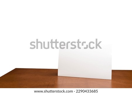 Blank menu frame label mockup in restaurant bar stand for booklet with acrylic white sheet paper tent card on wooden table. White isolated background can insert customer message. clipping path
