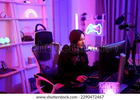 Asian cute player woman thinking strategy game plan about support team for win in pink neon light room at apartment