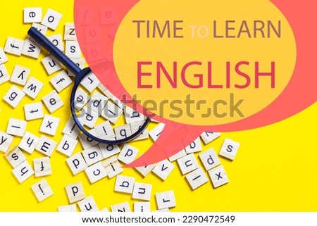 English alphabet made of square wooden tiles with the English alphabet scattered on yell0w background. The concept of thinking development, grammar. Magnifier placed on English letters Royalty-Free Stock Photo #2290472549