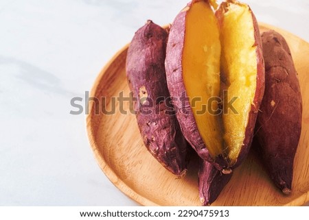 Grilled or baked Japanese sweet potatoes on wood plate - Japanese food style Royalty-Free Stock Photo #2290475913