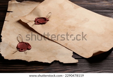 Sheets of old parchment paper with wax stamps on wooden table