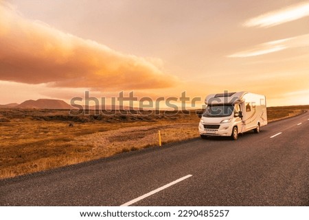 RV Motorhome camper van road trip. People on travel vacation adventure. Tourists in rental car campervan by view of mountains in beautiful nature landscape at sunset. From Iceland. Royalty-Free Stock Photo #2290485257
