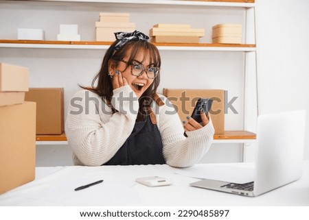 Photo of  excited young female self employed  sitting at work desk focused on mobile phone screen. Women young enterpreneur arranger reading email with profitable offer from potential customer Royalty-Free Stock Photo #2290485897