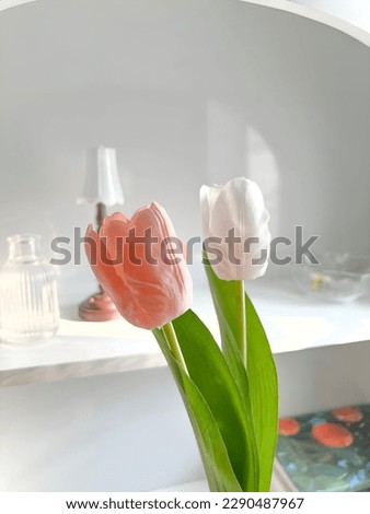 White and pink tulips and a vintage and minimalist fireplace shelf.