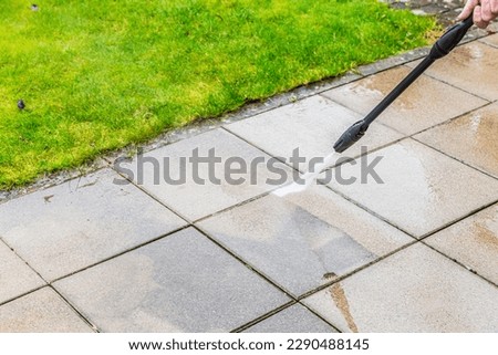 Detail of cleaning terrace with high-pressure water blaster, cleaning dirty paving stones Royalty-Free Stock Photo #2290488145