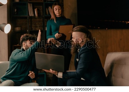 Three coworkers working remotely. Two male people giving high five to each other after successfully finished daily task