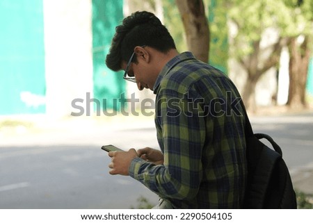 portraits of young asian man using smartphone walking on street