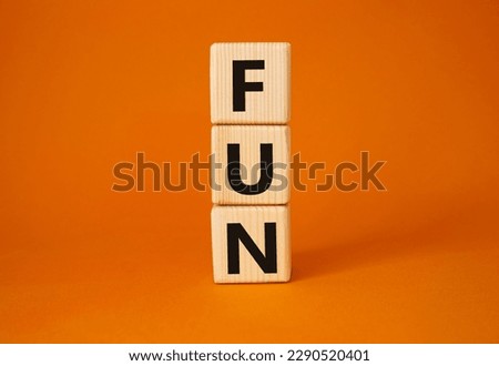 FUN symbol. Wooden cubes with word FUN. Beautiful orange background. FUN concept. Copy space.