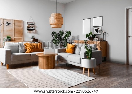 Interior of living room with green houseplants and sofas Royalty-Free Stock Photo #2290526749