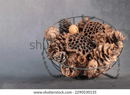 Dried pine cones and lotus seeds are placed in an iron basket.