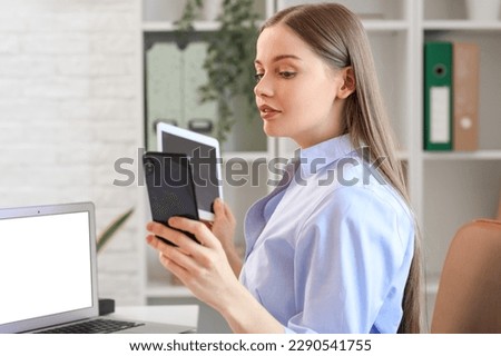 Young businesswoman with mobile phone and tablet computer in office. Balance concept