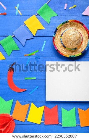Blank card with Mexican symbols, flags and confetti on blue wooden background