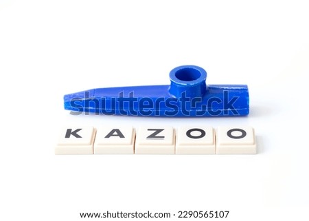Blue Kazoo. Kazoo lettering isolated on white background. Wind instrument idea concept. Horizontal photo. Simple musical instrument for kids. No people, nobody. Copy space. Blank. Empty.