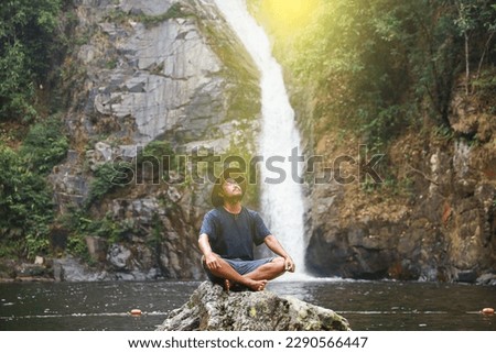 mature man  in outdoor leisure activity alone. Male people in meditation with waterfall background.