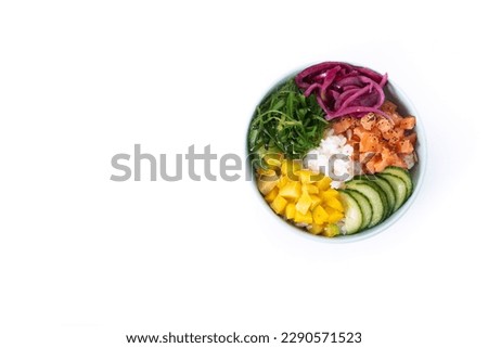 Poke bowl with rice, salmon,cucumber,mango,onion,wakame salad, poppy seeds ands sunflowers seeds isolated on white background. Top view. Copy space