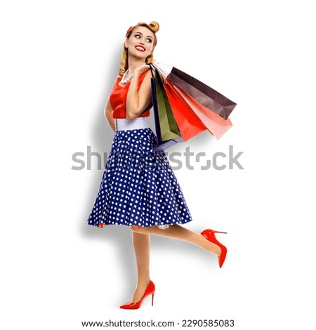 Full body of very happy, cheerful excited looking up woman in pinup dress holding, carrying many shopping bags, isolated on white background. Sales discounts rebates or consumer bank credit ad. Square