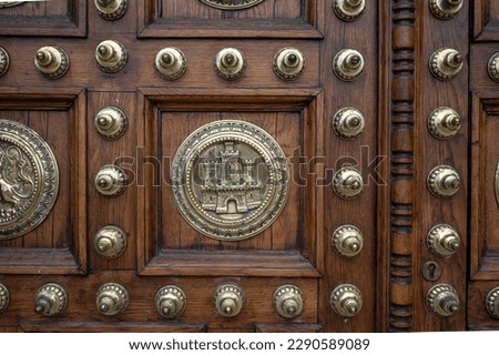 Detail of the metal inlays and patterns of the beautiful wooden door of the general captaincy of barcelona Royalty-Free Stock Photo #2290589089