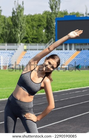 young woman warms up before jogging on stadium, People sport and fitness concept.