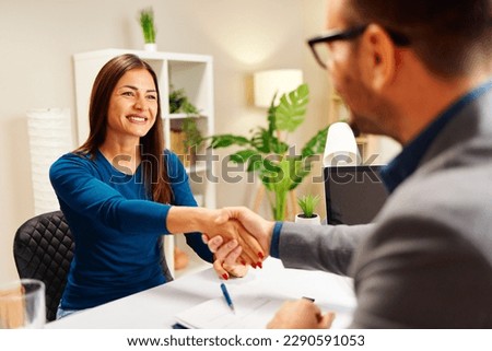 Young woman shakes hands with the manager after signing the contract