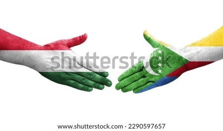 Handshake between Comoros and Hungary flags painted on hands, isolated transparent image.