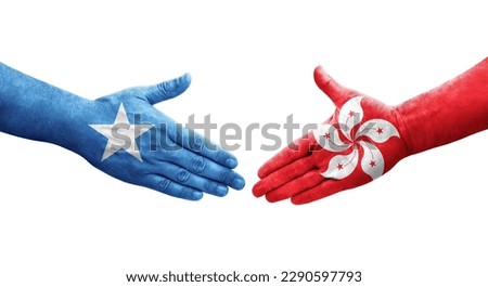 Handshake between Hong Kong and Somalia flags painted on hands, isolated transparent image.