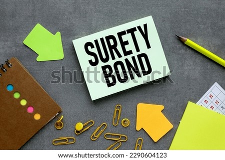 text on green sticker. on a gray background near bright stickers and paper clips SURETY BOND. Business concept Royalty-Free Stock Photo #2290604123