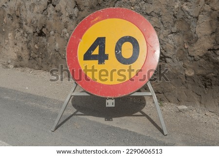 yellow and red speed limit 40 sign on a street