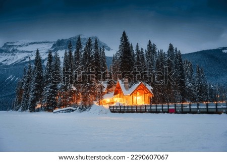 Beautiful view of Emerald Lake with wooden lodge glowing in snowy pine forest on winter at Yoho national park, Alberta, Canada Royalty-Free Stock Photo #2290607067