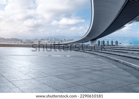 Empty square floor and bridge with city skyline in Sanya, Hainan, China. Royalty-Free Stock Photo #2290610181
