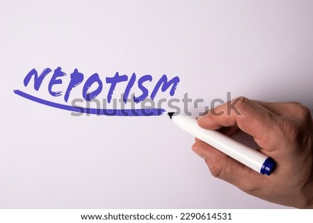 Nepotism. Handwriting text with marker on a white background.