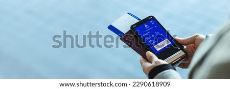 Closeup of a woman with electronic boarding pass on phone with passport and flight ticket at airport. Digital airplane ticket on the smartphone mobile app. Royalty-Free Stock Photo #2290618909