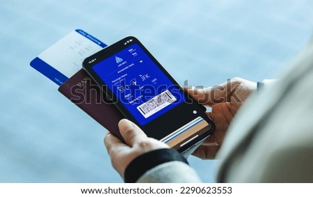 Traveler holding mobile phone with electronic boarding pass on the screen. Passenger using digital boarding pass for air travel. Royalty-Free Stock Photo #2290623553