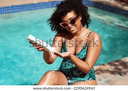 Young beautiful multi-ethnic woman applies sunscreen at the pool summer sun Royalty-Free Stock Photo #2290624963