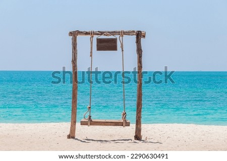 Wood swings for relaxation on the white sand beach  and turquoise water.