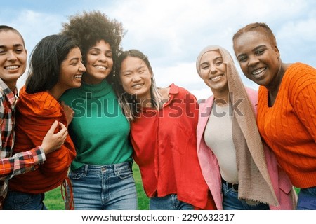 Multiracial group women friends hugging each other outdoors at park city - International people having fun smiling together - Focus on African curvy girl face Royalty-Free Stock Photo #2290632317