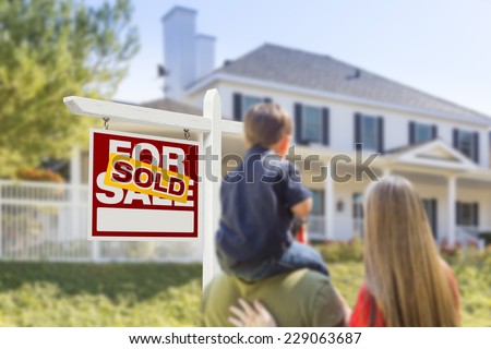 Curious Family Facing Sold For Sale Real Estate Sign and Beautiful New House.