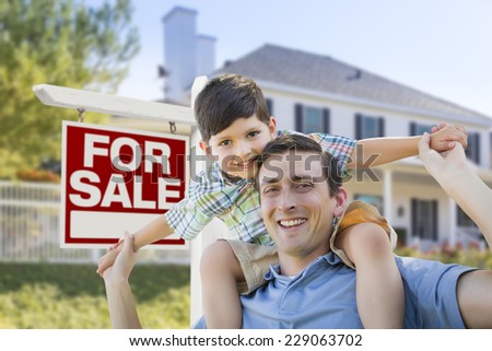 Mixed Race Father and Son Piggyback in Front House and For Sale Real Estate Sign.