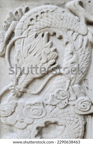 concrete wall with carvings in the shape of dragons