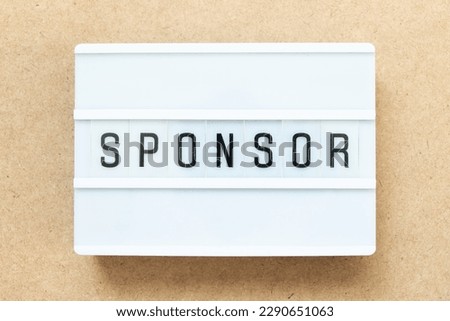 Lightbox with word sponsor on wood background
