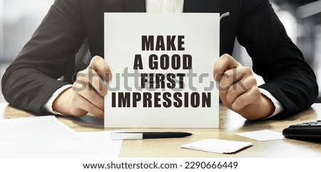 Businessman holding a white card with text Make a good first impression on office background Royalty-Free Stock Photo #2290666449