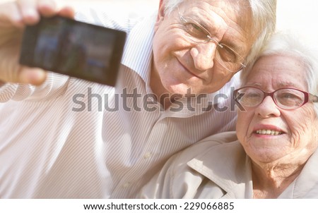 Man and senior woman taking selfie with retro filter effect